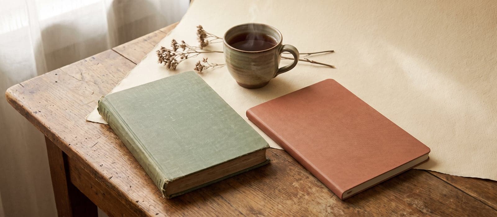 Two different notebooks side by side sharing one cup of tea