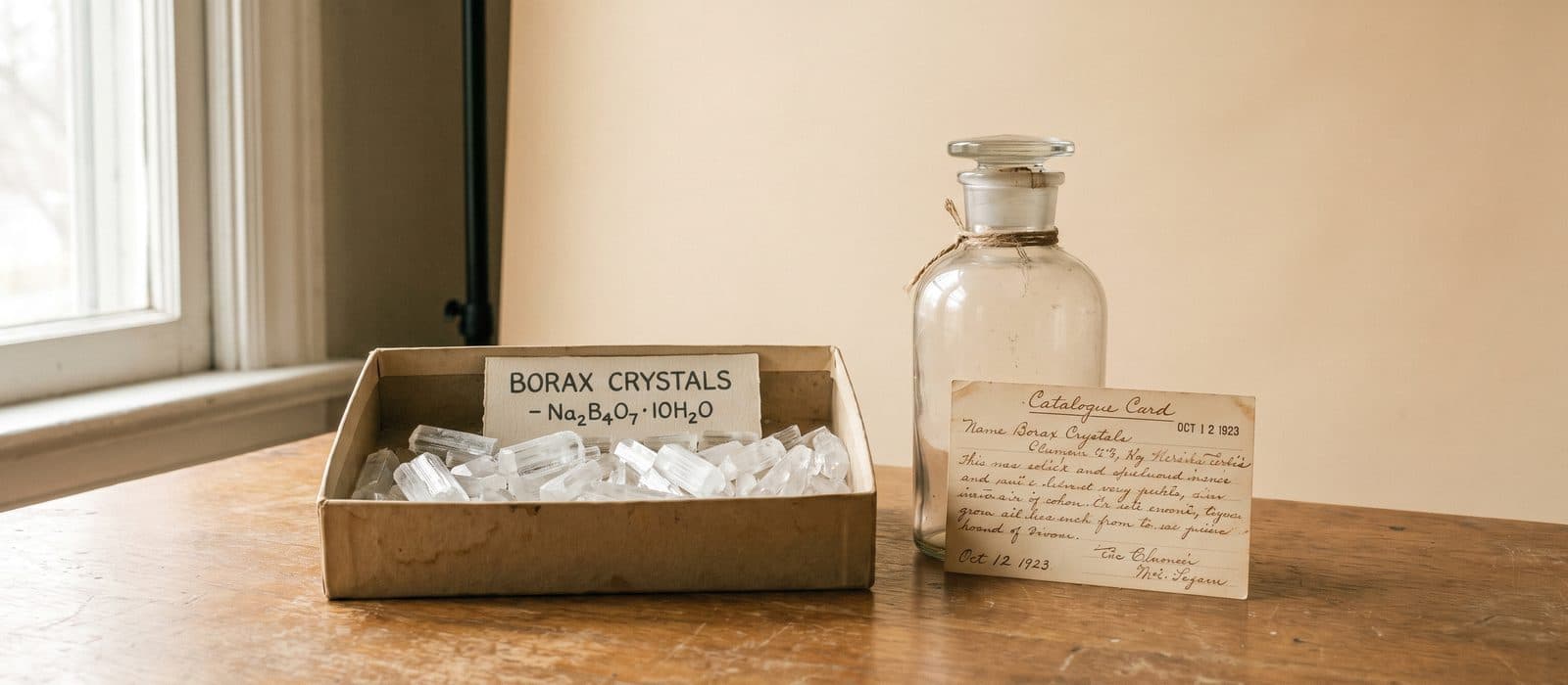 Colourless borax crystals in a labelled specimen tray