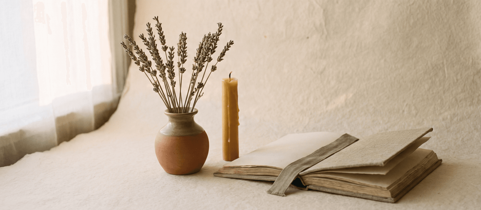 Lavender sprigs, a candle, and an open journal in low evening light