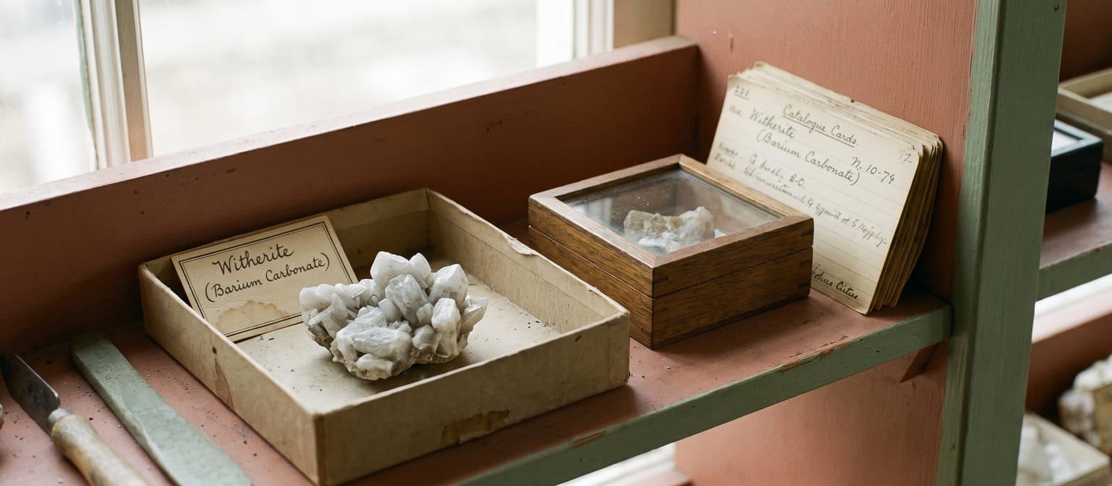 White witherite mineral crystals in a specimen tray